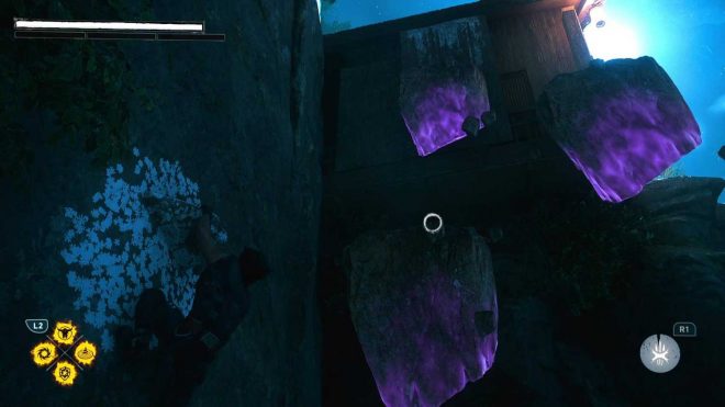 Logan hanging from a cliff while Jean Grey holds purple rocks in the air for him to jump to in Marvel's Wolverine.